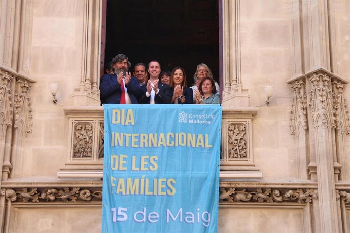 El presidente del Consell de Mallorca, Llorenç Galmés, junto a otros miembros de la institución cuelgan una bandera con motivo del día de las Familias