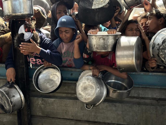 02 de maio de 2025, Territórios Palestinos, Khan Yunis: Palestinos lutam para receber refeições quentes distribuídas por organizações de caridade em meio aos contínuos ataques israelenses e ao bloqueio total de Gaza. Foto: Doaa El-Baz/APA Images via ZUMA 