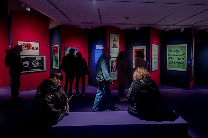 Varias personas observan la exposición ‘Andy Warhol. Posters’, en la Fundación Canal, a 20 de abril de 2025, en Madrid (España).