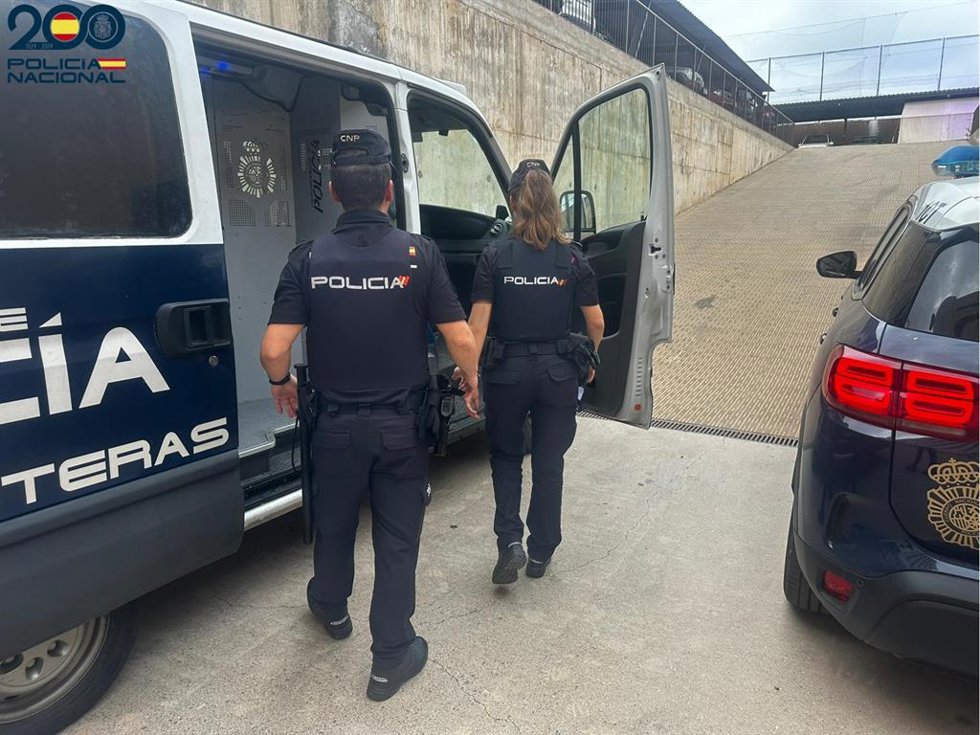 Archivo - Dos agentes de la Policía Nacional de Ibiza junto a un furgón.