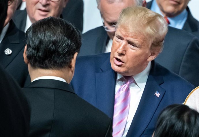 Archivo - FILED - 28 June 2019, Japan, Osaka: Xi Jinping (L), President of China, and US President Donald Trump speaks as they join fora group picture at the beginning of the G20 summit.