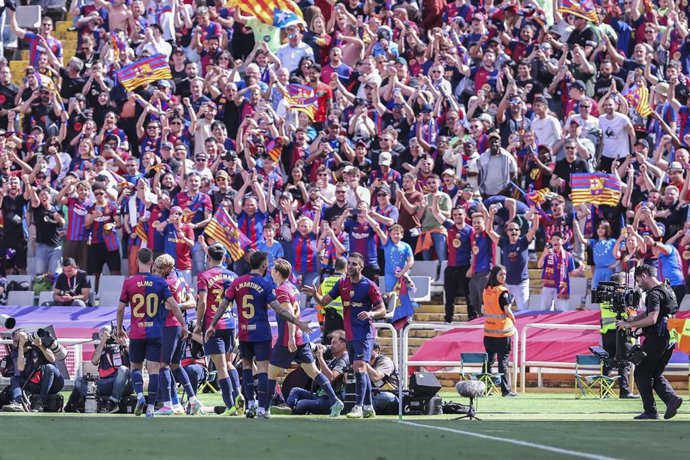 Raphinha Dias Belloli, do FC Barcelona, comemora um gol com seus companheiros de equipe durante a partida de futebol do campeonato espanhol, La Liga EA Sports, disputada entre FC Barcelona e Real Madrid no Estadi Olimpic Lluis Companys em 11 de maio de 20