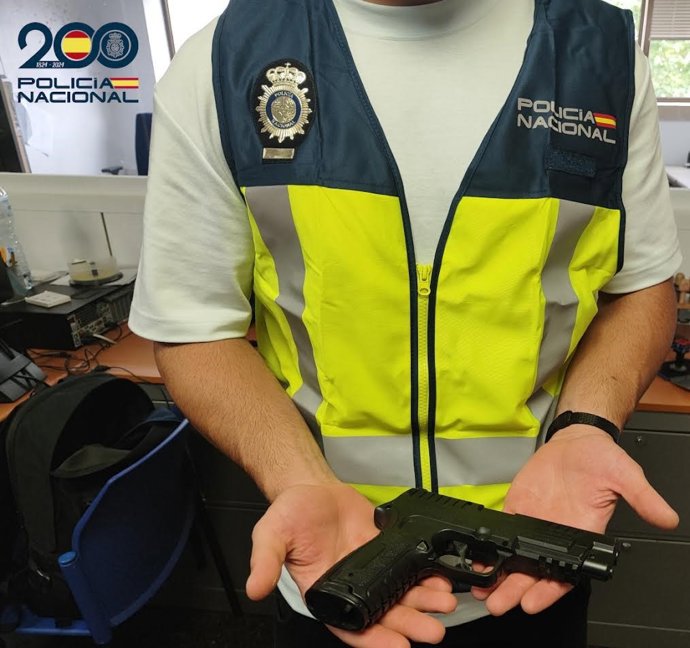 Archivo - Agente de la Policía Nacional sosteniendo una pastola simulada