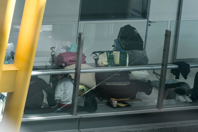 Varias personas se preparan para pernoctar en la T4 del Aeropuerto Adolfo Suárez-Madrid Barajas, a 12 de mayo de 2025, en Madrid (España).