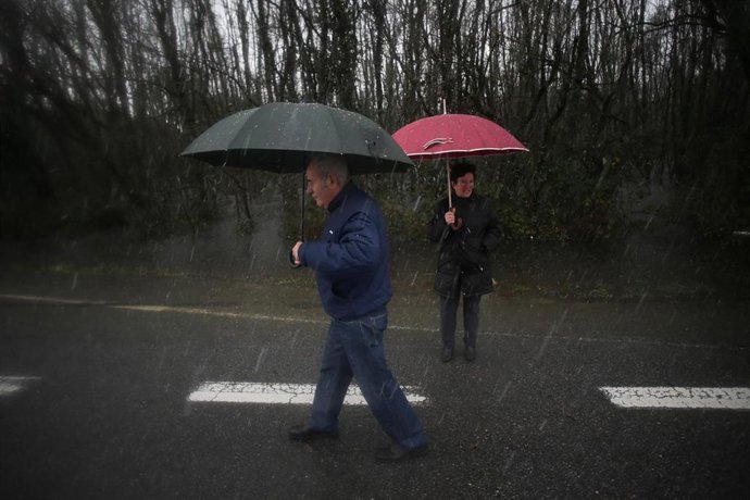 Archivo - Dos personas sujetan un paraguas a causa de las lluvias, a 17 de enero de 2023, en Begonte, Lugo, Galicia (España).