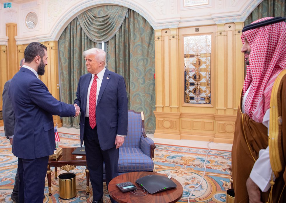 14 May 2025, Saudi Arabia, Riyadh: Saudi Crown Prince Mohammed bin Salman (R) looks on as US President Donald Trump (C) shakes hands with Syria's interim President Ahmad al-Sharaa (L) in Riyadh. Photo: -/Saudi Press Agency/dpa