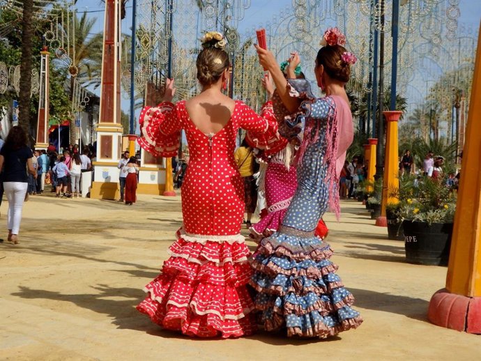 Varias mujeres con trajes de gitana en el real de la Feria del Caballo de Jerez de la Frontera (Cádiz).