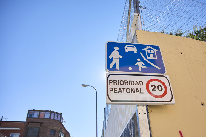 Una señal de tráfico indica la presencia de una zona peatonal y la obligatoriedad de circular a 20 km por hora, en las inmediaciones del colegio público.