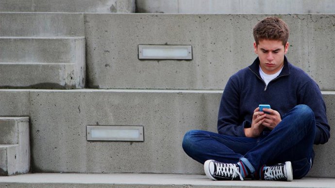Un joven sujera un móvil (imagen de recurso)