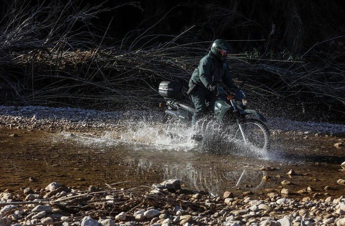 Archivo - Un agente de la Guardia Civil en moto busca a un desaparecido en los barrancos del río Turia, en Pedralba