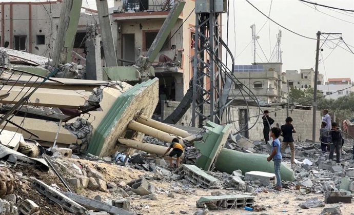 Palestinos ante los restos de la mezquita Al Hasanat, destruida por Israel en sus bombardeos contra el campamento de refugiados de Nuseirat, en la Franja de Gaza (archivo)