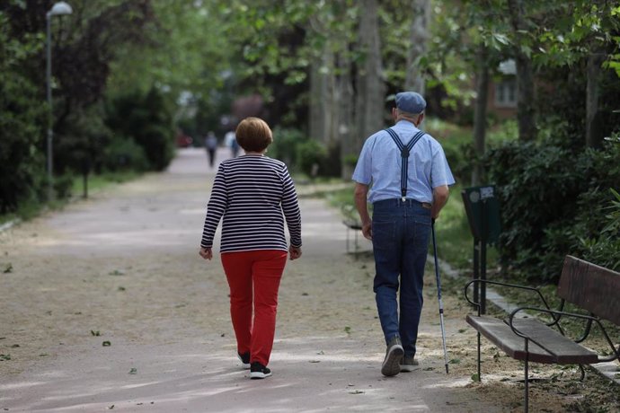 Archivo - Una mujer y un hombre de edad avanzada caminando, en una imagen de archivo