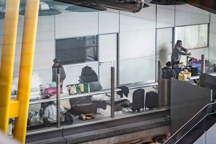Varias personas se preparan para pernoctar en la T4 del Aeropuerto Adolfo Suárez-Madrid Barajas