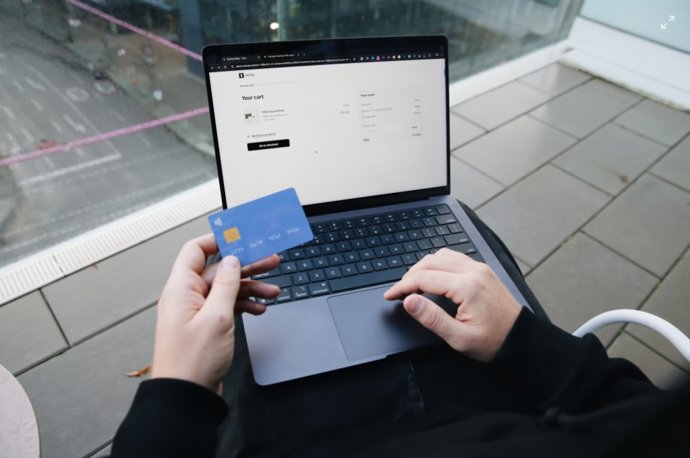 Recurso de uma pessoa fazendo compras em um site a partir de um laptop.