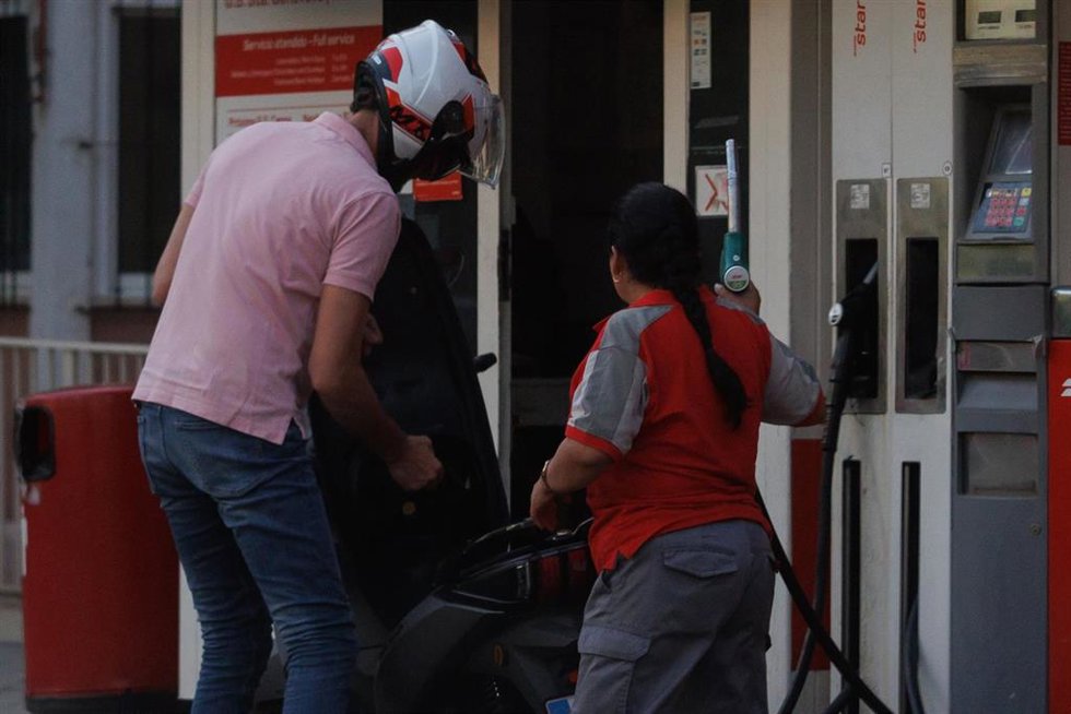 Archivo - Un hombre echa carburante a su vehículo en una gasolinera
