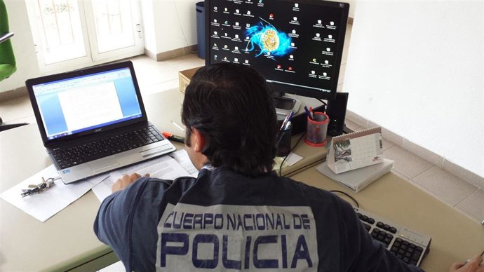 Archivo - Agente policial ante un ordenador.