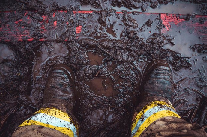 Trabajador de emergencias con las botas embarradas