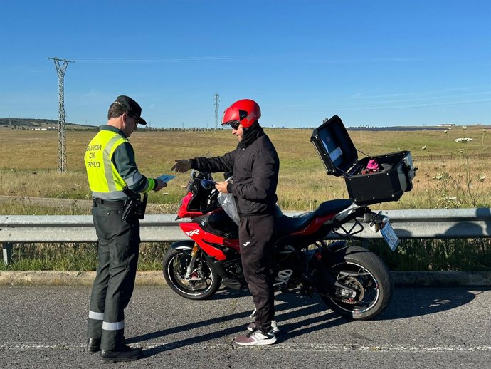 La Guardia Civil de Tráfico informa a un motorista sobre las normas de circulación por carretera