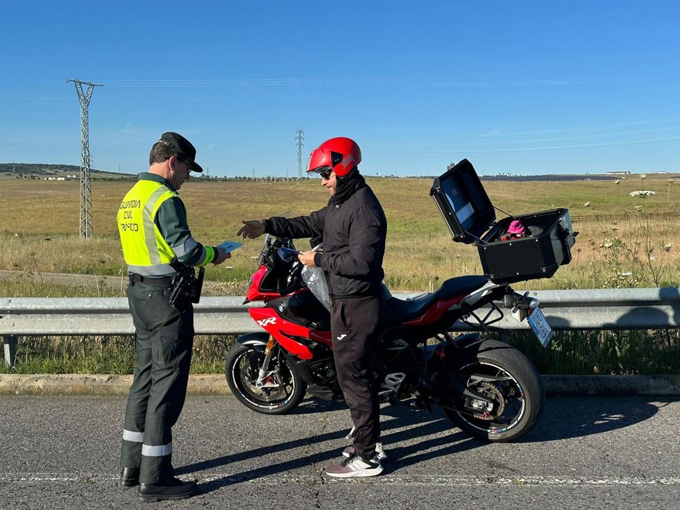 La Guardia Civil de Tráfico informa a un motorista sobre las normas de circulación por carretera