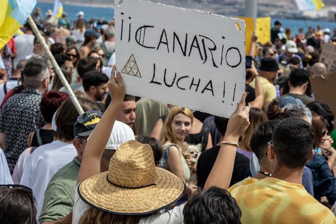 Archivo - Una persona sujeta un cartel de protesta durante una manifestación contra el modelo turístico, a 20 de abril de 2024, en Las Palmas de Gran Canaria, Gran Canaria