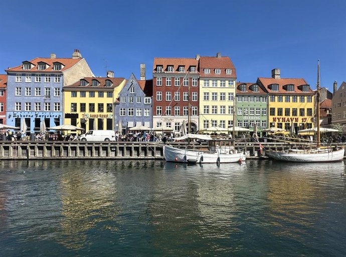 FILED - 29 April 2025, Denmark, Copenhagen: Passers-by walk along the Nyhavn (new harbor). Nyhavn, with its colorful little houses, is one of the most important sights in the Danish capital.