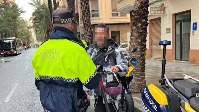 Un agente de la Policía Local de Alicante con un usuario de un patinete eléctrico