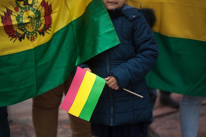Archivo - 17 de novembro de 2019, Málaga, Espanha: Uma criança segura uma bandeira durante o protesto... Os bolivianos realizaram um protesto em apoio a seus compatriotas e contra o governo do ex-presidente Evo Morales.
