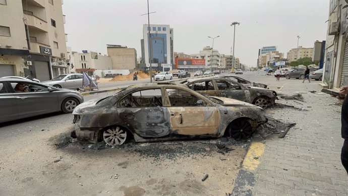 TRIPOLI, May 14, 2025  -- This photo taken on May 14, 2025 shows damaged vehicles during violent clashes on a street in Tripoli, Libya. Libya's Tripoli-based Government of National Unity (GNU) declared a ceasefire on Wednesday following intense overnight 