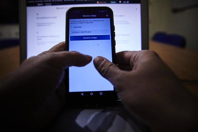 Archivo - Una persona con el móvil y el ordenador encendidos, en Madrid (España), a 9 de febrero de 2021.  Este martes 9 de febrero se celebra el Día de la Internet Segura, que en esta edición está inevitablemente marcado por la pandemia y el confinamient