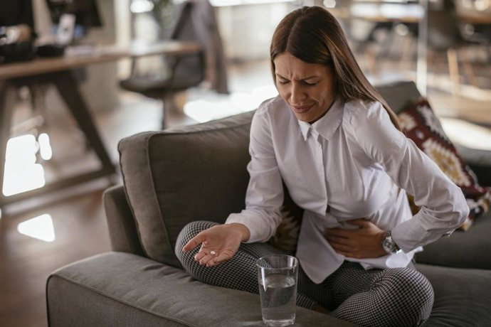 Archivo - Dolor, tratamiento, pastilla, mujer en el salón
