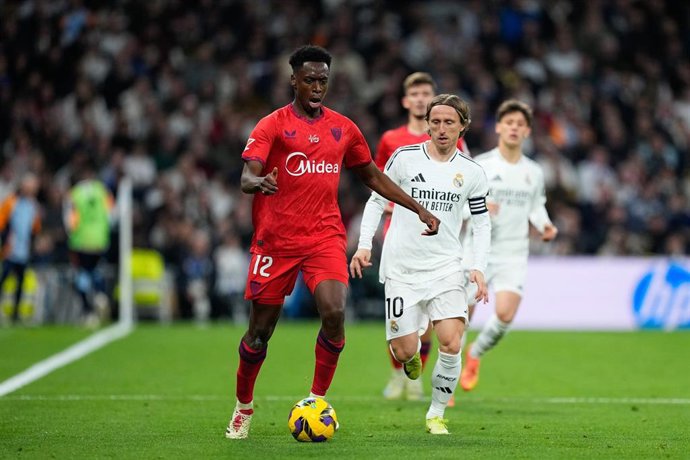 Archivo - El jugador del Sevilla FC Sambi Lokonga conduce el balón ante el mediocentro del Real Madrid Luka Modric en un partido en el Santiago Bernabéu.