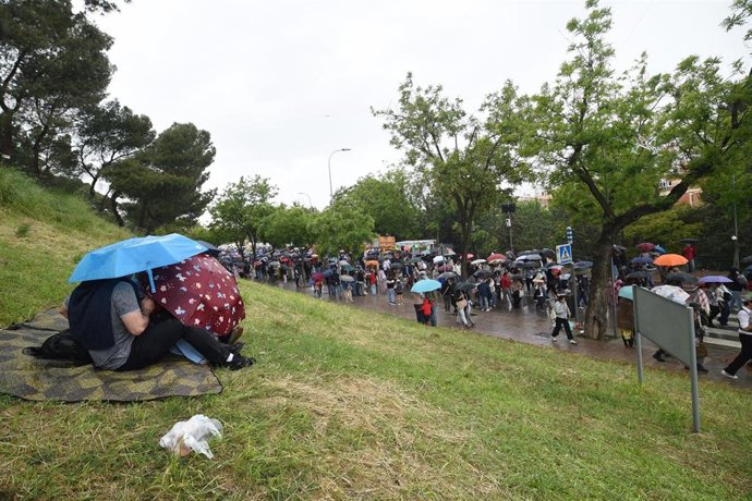 Decenas de personas se protegen de la lluvia en la pradera de San Isidro, a 15 de mayo de 2025, en Madrid (España). La ciudad de Madrid celebra la festividad de su patrón, San Isidro, con unas fiestas que comprenden este año más de 200 eventos previstos c