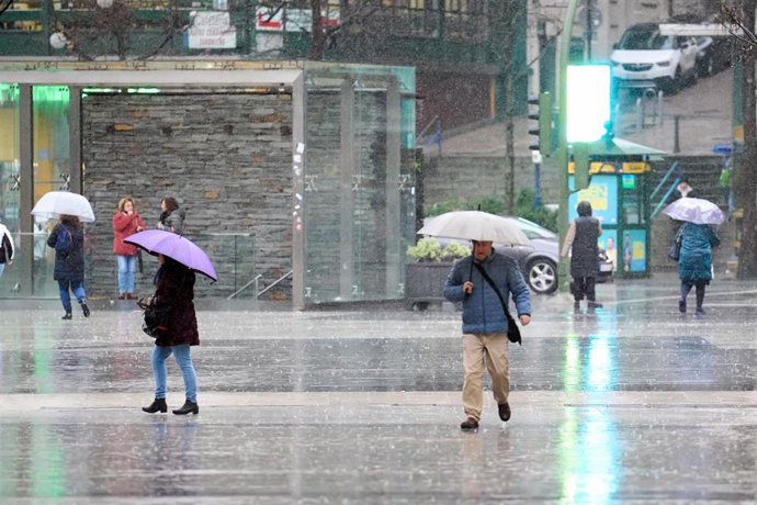 Archivo - Varias personas con paraguas cruzan un paso de cebra en Santander.-ARCHIVO