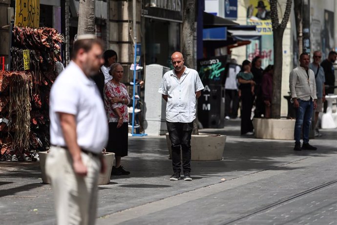 April 30, 2025, Jerusalem, Israel, ISRAEL: People stand still as a siren sounds marking Israel's Memorial Day, when the country commemorates fallen soldiers of Israel's wars and Israeli victims of hostile attacks, on a street in Jerusalem, April 30, 2025.