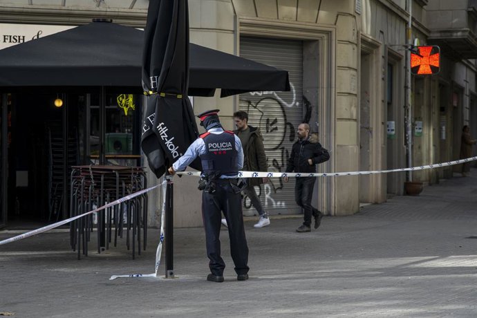 Archivo - Un agent acordona la zona on es va trobar un cadàver en un contenidor del centre de Barcelona