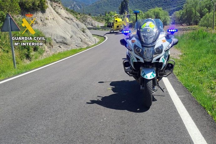 Una motocicleta de la Guardia Civil con el helicóptero del 112 al fondo en unas de las intervenciones llevadas a cabo en dos accidentes ocurridos este domingo en la provincia de Huesca, en Yésero y Las Peñas de Riglos.