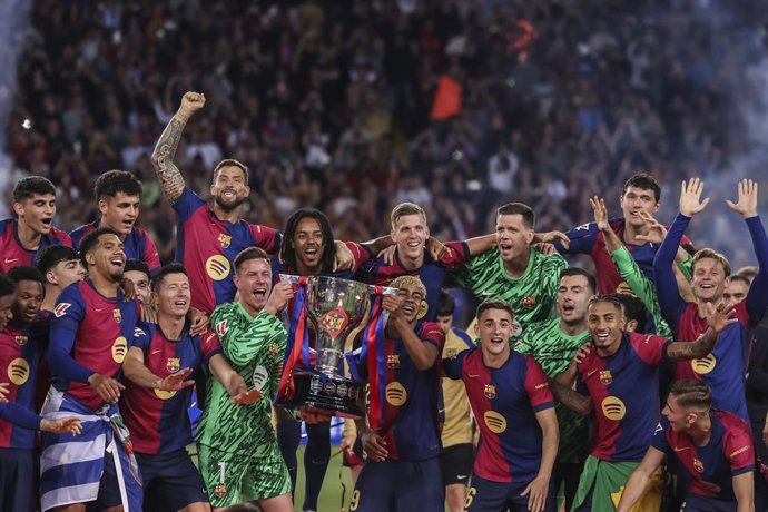 Jogadores do FC Barcelona comemoram com o troféu após a partida de futebol do campeonato espanhol, La Liga EA Sports, disputada entre o FC Barcelona e o Villarreal CF no Estadi Olimpic Lluis Companys em 18 de maio de 2025 em Barcelona, Espanha.