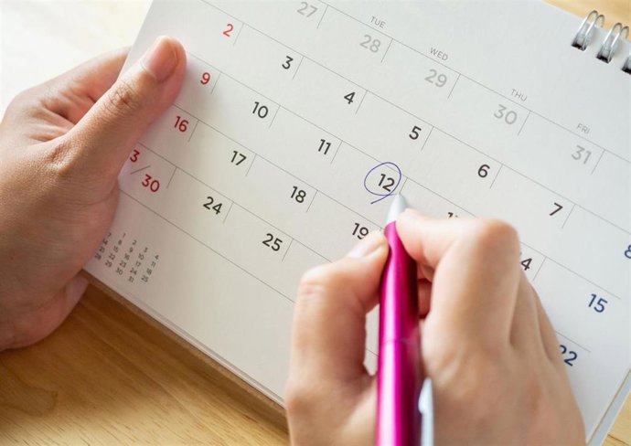 Una persona realiza anotaciones en un calendario.