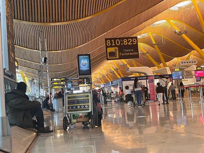 Una persona sin hogar entre los pasajeros de la T4 de Barajas
