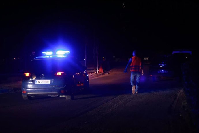 Un coche de la Policía Nacional recorre una calle a oscuras durante el apagón eléctrico generalizado en el barrio de Sevilla Este