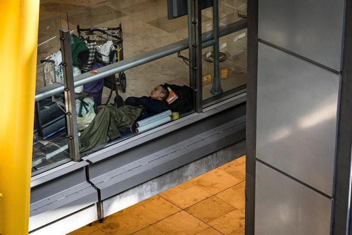 Un hombre duerme en la T4 del Aeropuerto Adolfo Suárez-Madrid Barajas