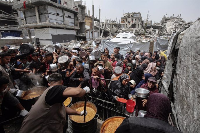 30 April 2025, Palestinian Territories, Jabalia: Palestinians struggle to receive hot meals distributed by charity organizations amid the ongoing Israeli attacks and total blockade on Gaza, in Jabalia camp. Palestinians of all ages endure long and sometim