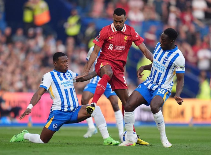 19 May 2025, United Kingdom, Brighton: Brighton and Hove Albion's Pervis Estupinan, Liverpool's Ryan Gravenberch and Brighton and Hove Albion's Danny Welbeck battle for the ball during the English Premier League soccer match between Brighton and Hove Albi