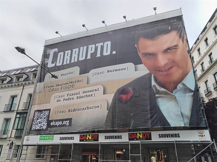 Hazte Oír despliega una lona frente al Congreso con una imagen de Pedro Sánchez acompañado del lema "Corrupto"