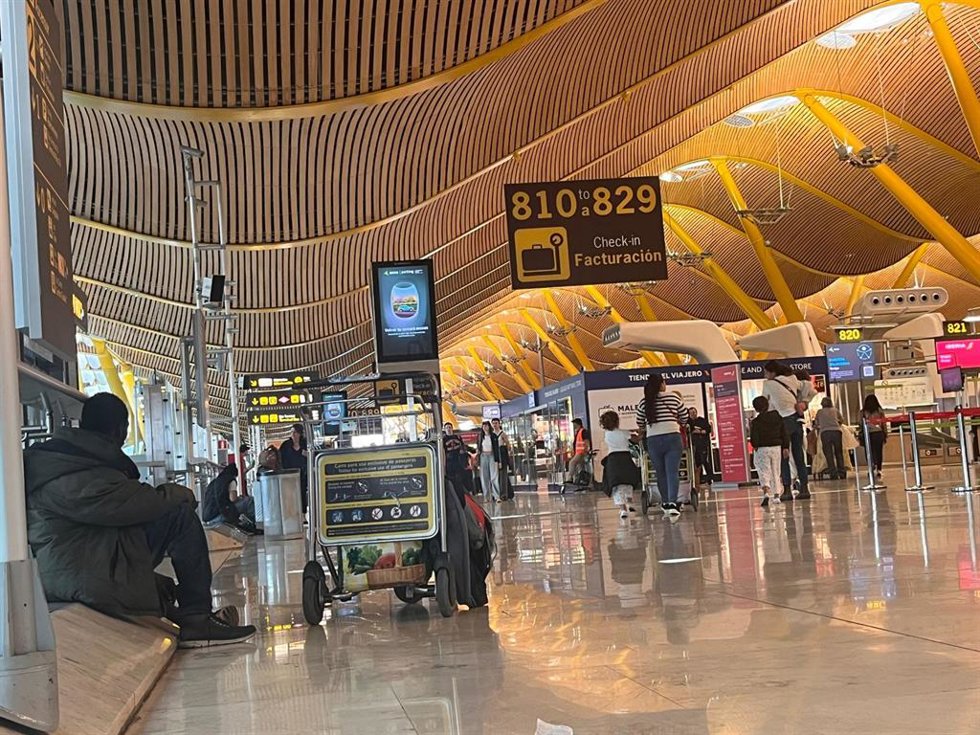 Una persona sin hogar entre los pasajeros de la T4 de Barajas, Madrid, el 13 de mayo de 2025.