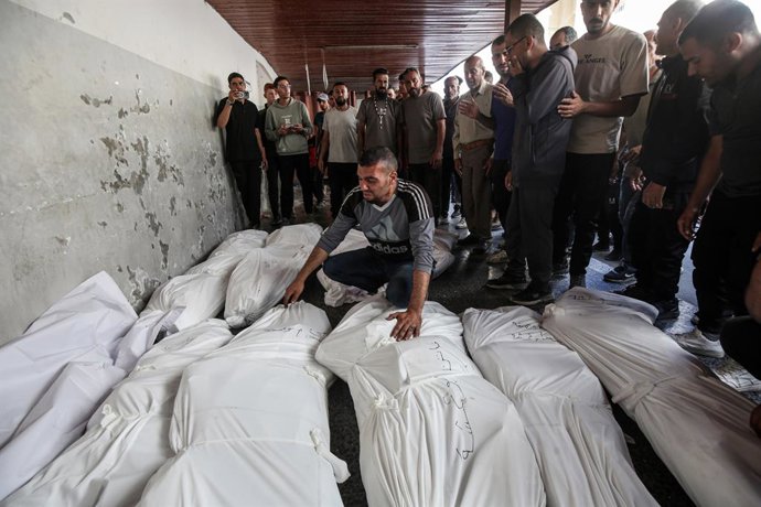 Palestinos no Hospital Batista na Cidade de Gaza ao lado dos corpos de várias pessoas mortas pelos ataques do exército israelense na Faixa de Gaza.