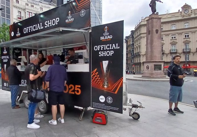 Algunos aficionados comprando recuerdos de la final que se celebrará este miércoles.