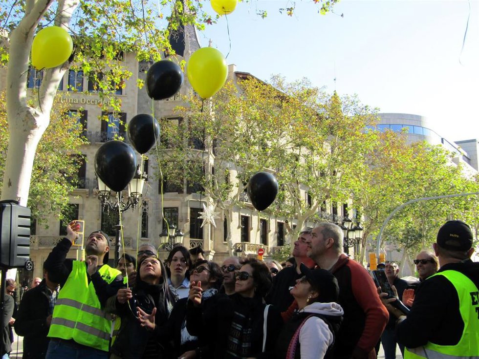 Archivo - La familia del taxista muerto lanza unos globos negros y amarillos al cielo