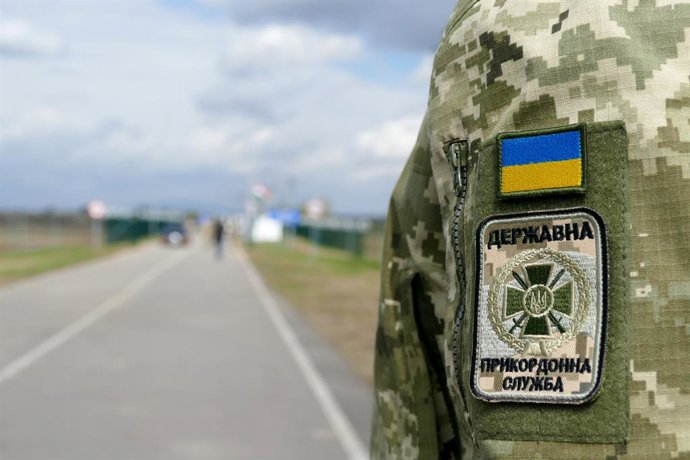 Archivo - Arquivo - 8 de abril de 2025, região de Zakarpattia, Ucrânia: Os emblemas da bandeira ucraniana e do Serviço Estatal de Guarda de Fronteiras da Ucrânia estão no uniforme durante a abertura do posto de controle Velyka Palad-Nagyhodos na fronteira
