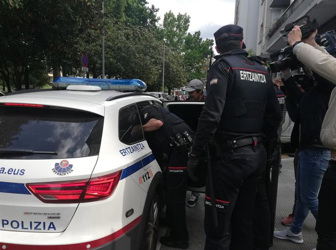 Archivo - Ertzainas junto a un coche policial durante una detención